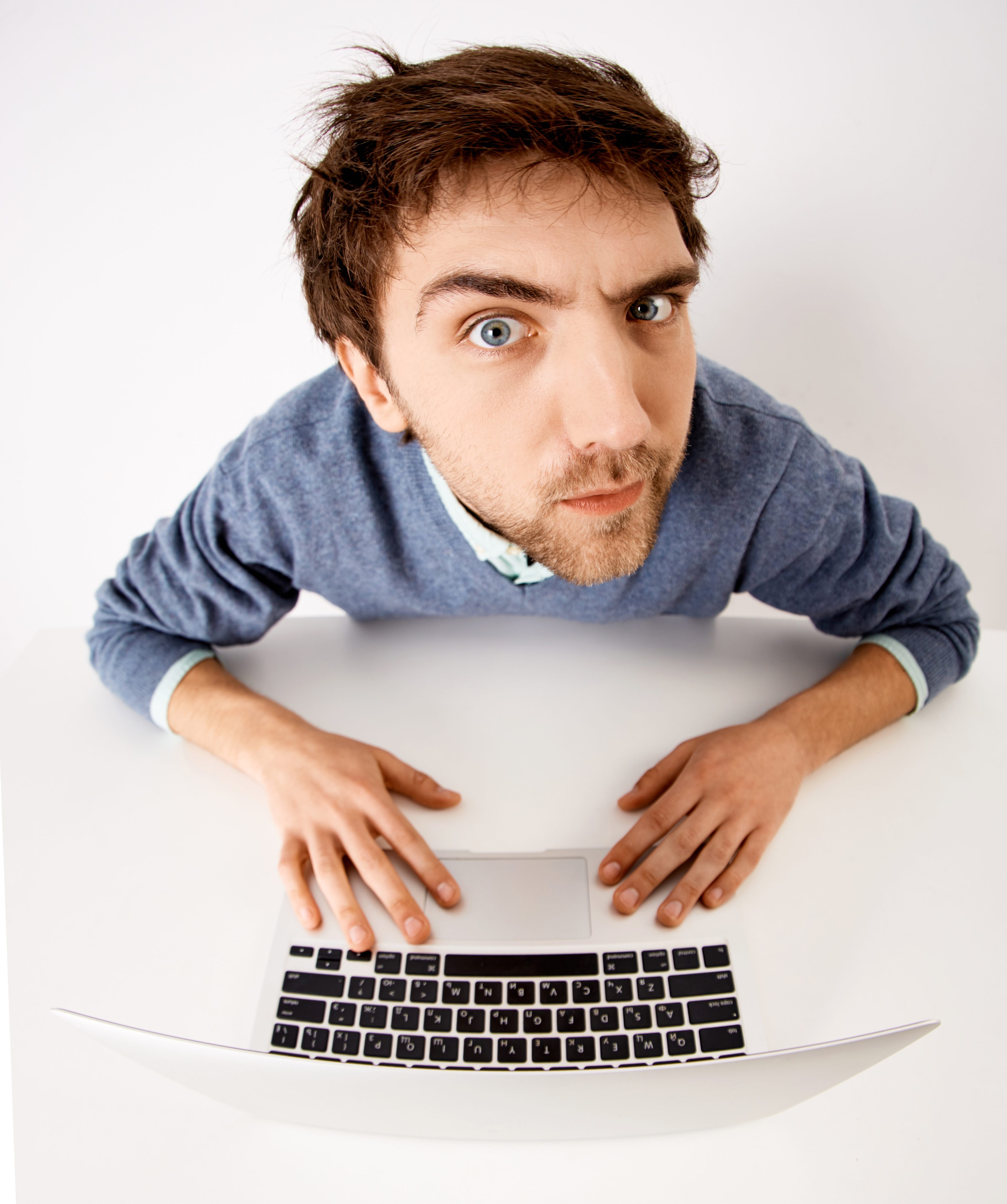 Crazy businessman chatting on his laptop and looking at camera